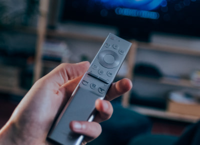  A person holding a grey remote control