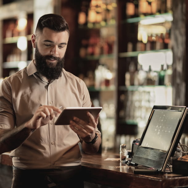 A bartender studying the menu on a tablet