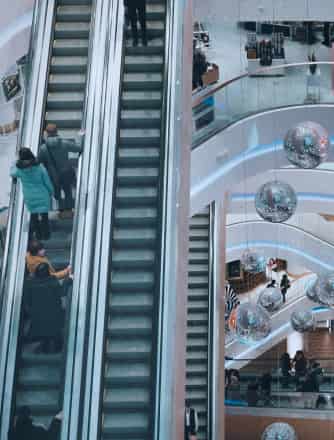 People standing on an escalator in a mall