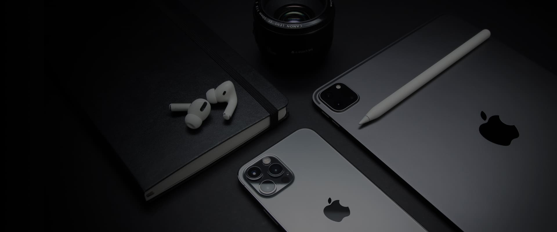 Apple devices lying on a black surface
