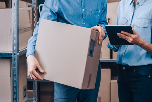 Two people in a warehouse planning parcel delivery