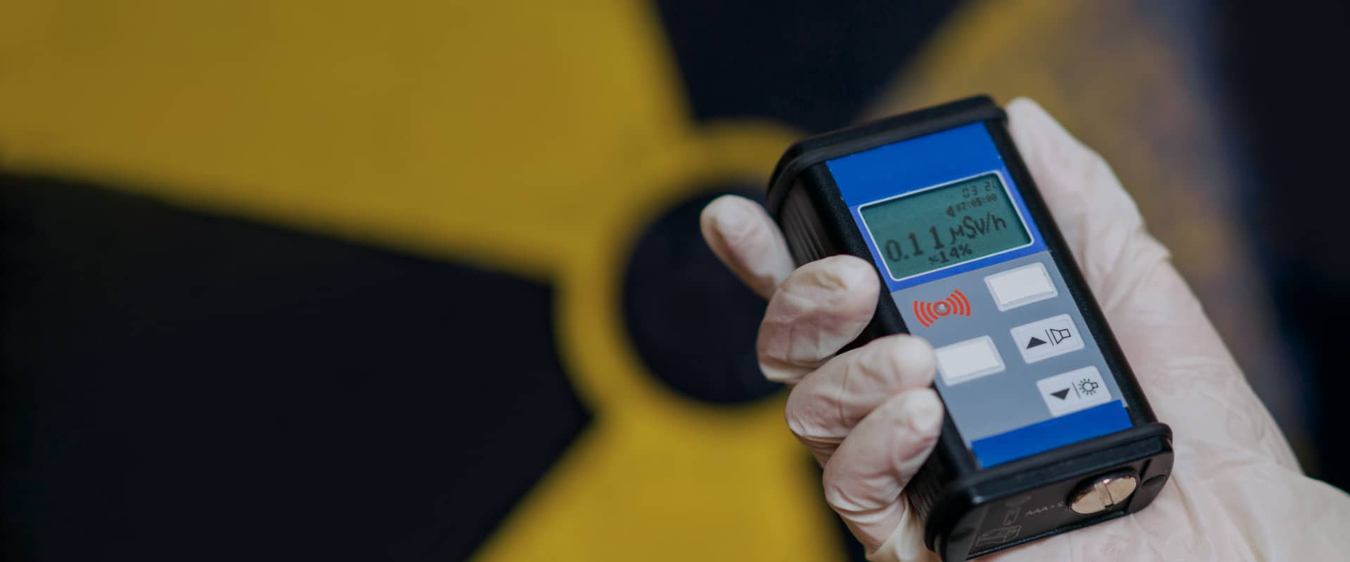 A person holding a device on Ionizing radiation hazard symbol background