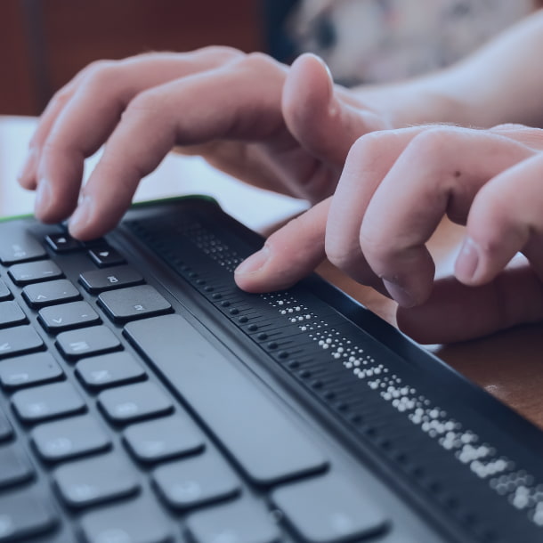 A person with special needs operates a low-vision keyboard