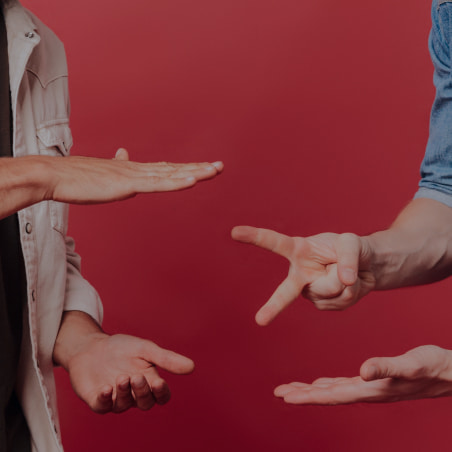 Two people play Rock paper scissors game on a red background