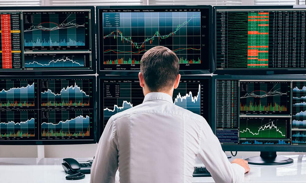 A person is monitoring the activity on stocks market using 6 monitors