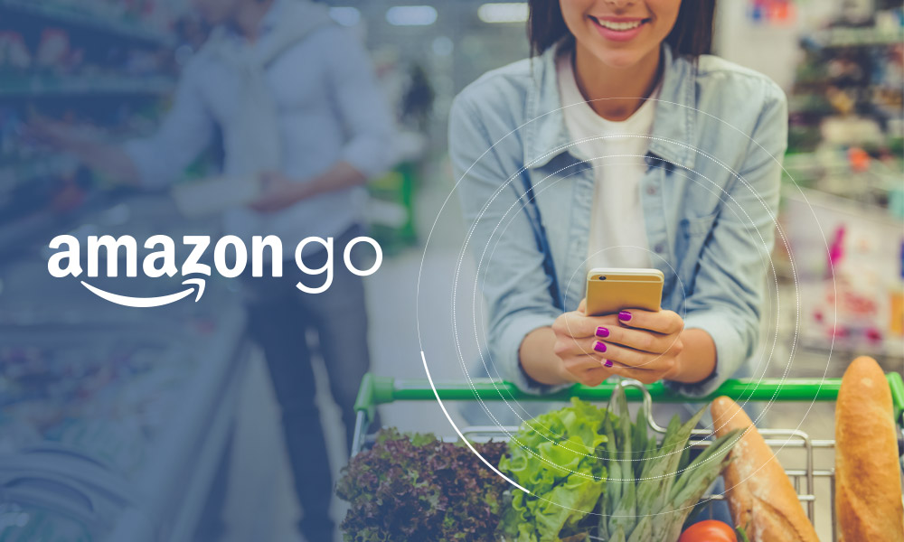 A person pushing a trolley with groceries and using the phone next to Amazon Go logo