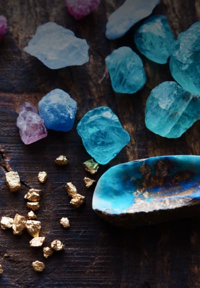 Gemstones and precious metals on a wooden desk