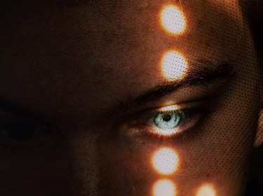 A human eye and several light points on the face
