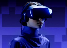 A woman wearing a blue headset and headphones, focused on her task, with a neutral background.